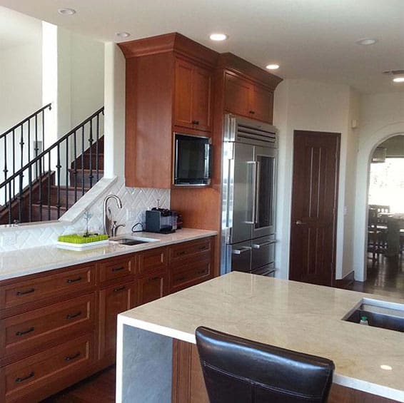 A stylish white kitchen showcasing a generous island and a dining table, perfect for gatherings and meal preparation.